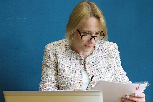 Helen Morgan in her office examining documents