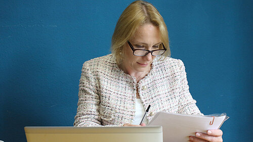 Helen Morgan in her office examining documents