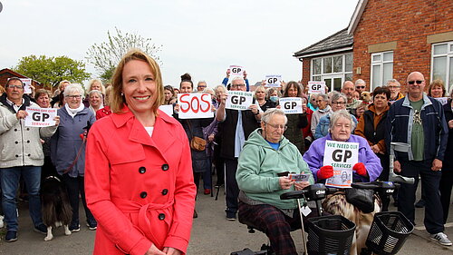 Helen Morgan with dozens of protesters outside the closed GP practice in St. Martins