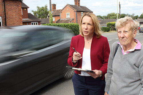 Helen Morgan and resident with vehicles speeding past