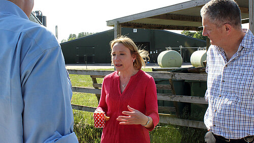 Helen talking to farmers at a local farm