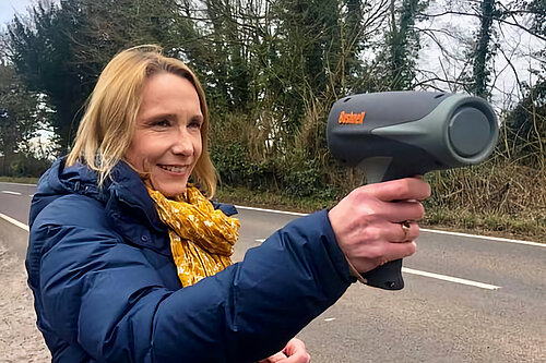 Helen uses a speed-gun to check speeding vehicles