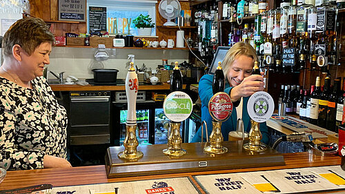 Helen Morgan pulling pints at the Red Lion pub