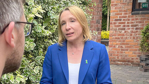 Helen Morgan wearing a green ribbon pin badge